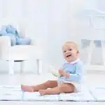 baby playing with his bottles instead drinking