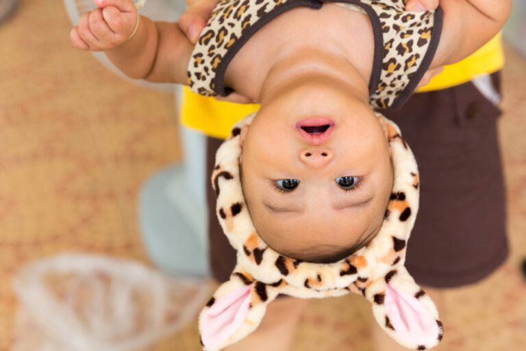 baby hangs upside down